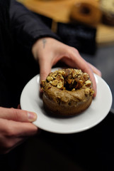 girl holds a delicious donut with nuts
