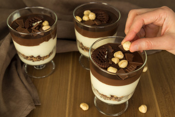 Service chocolate magnolia dessert with hazelnut on the wooden background.