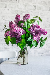 Fresh bouquet of lilacs on the table in a bright room. Home interior concept