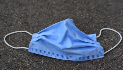 Close-up of a used surgical pulp face mask lying on the floor