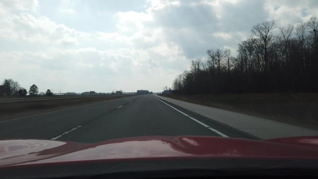 Red Sports Car Hood Driving Down Empty Highway With Very Little Oncoming Traffic