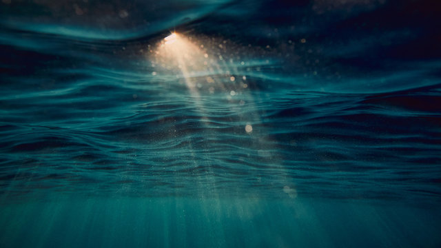 surface of the sea from underwater and sun flare