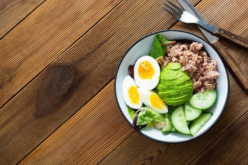Healthy tuna and egg salad with avocado and fresh green salad mix leaves.