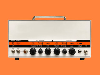 Isolated white iron modern drive medium electric guitar amplifier head on orange background with...