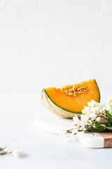 Fresh Cavaillon melon with white flowers on a white background.