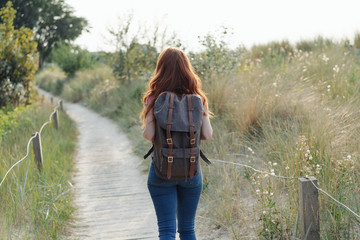 Young woman hiking along a wooden boardwalk
