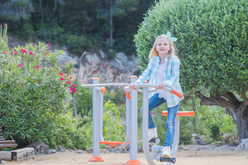 cute beautiful smiling little girl on a playground. Summer time fun