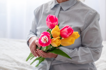 Women's hands hold a bouquet of tulips. Happy mother's day