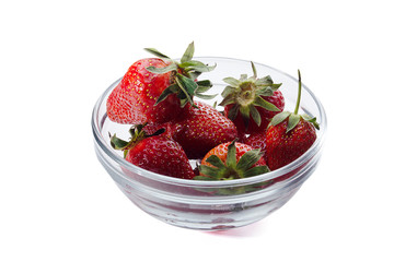 fresh red strawberries in a transparent salad bowl on a white background