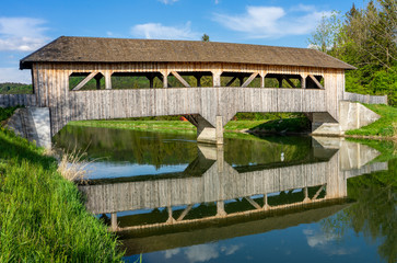 Fototapeta premium Überdachte Holzbrücke über den Isarkanal, nähe Icking und Schäftlarn bei der Aumühle