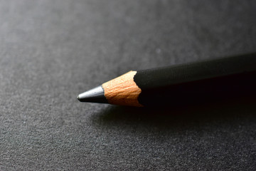 Black close-up pencil on a black background