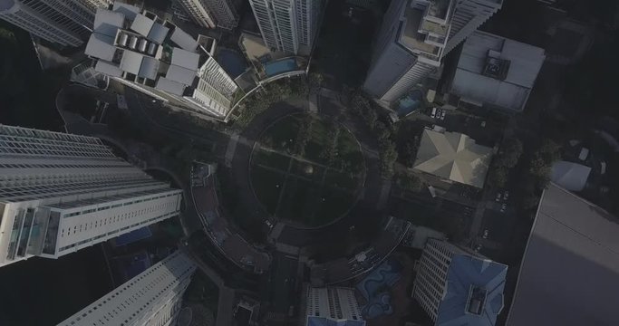Ungraded, Zoom out orbiting aerial flight above roundabout intersection in urban area. Drone, 4K.