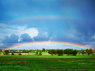 double rainbow after a thunderstorm over a green field