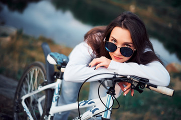 Fototapeta na wymiar Girl in the mountains on a Bicycle on the background of a lake, close-up portrait, resting, healthy lifestyle, Cycling, nature and man