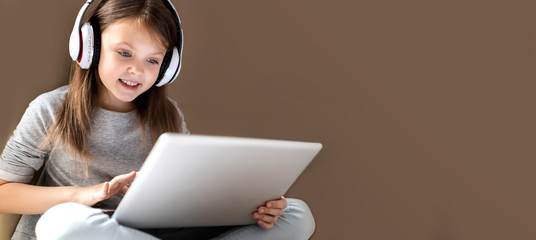 Kids distance learning. Cute clever little girl using laptop at home. Education, online study, home...