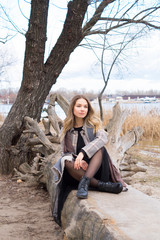 Smiling beautiful girl in a park in a fashionable coat. Checkered autumn coat