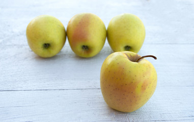 Emoji concept. Smiling fruit face. Yellow apples for eyes and a yellow banana for a smile on white background.