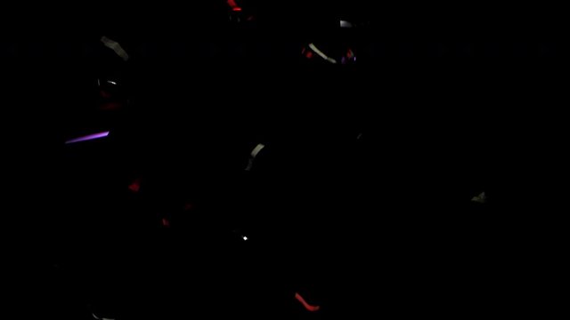 colorful tinsel lametta confetti falling top down in medium wide framing against black. VFX compositing plate shot with alpha channel