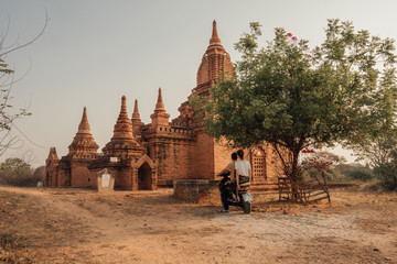 Couple rides a bike to visit a temple in Bagan, Myanmar, Burma