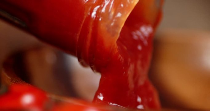 Tomato sauce poured from the glass jar.