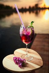 Red / purple cocktail / wine on sunset background