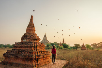 Woman watches sunrise over the temples of Bagan, Burma, Myanmar 