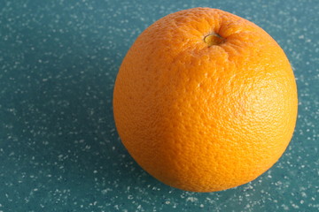 whole orange fruit on green board for cutting, closeup vitamain C