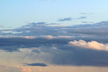 White fluffy clouds on a background of blue sky in summer. The concept of weather and climate.