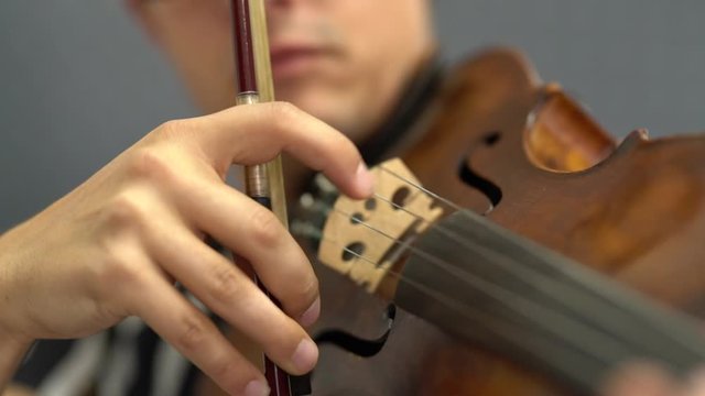 Musician playing violin with Pizzicato technique, close up