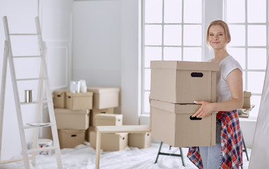 A beautiful single young woman unpacking boxes and moving into a new home