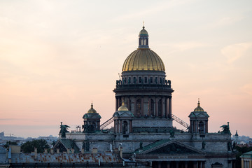 Fototapeta na wymiar Sunset view at the Isaak Cathedral from the roof of Saint-petersburg city. Ancient roof of the city. Old historical city. Amazing sunset at the top of the city.