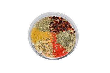 Colorful spices in plastic or glass bowl isolated on white background. Indian or east spice set. Top view macro. Curcuma, paprika, dried herbs, zira, laurel leaf.