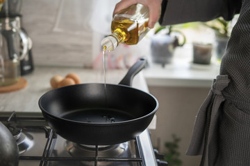 Dripping pan, olive oil and black induction cooker.