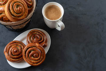 Buns with poppy seeds and a cup of coffee.