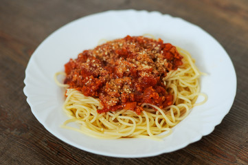 Fresh tasty spaghetti bolognaise served on plate on wooden table.