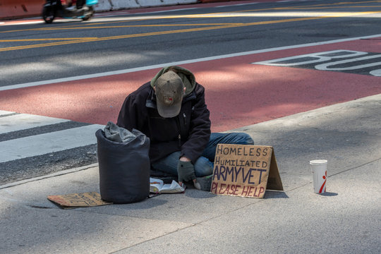 New York, USA - MAY 10, 2020: A homeless man sitting on the street asking for help
