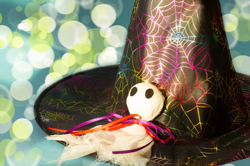 Magic hat and ghost on a light background. Halloween background. Traditional decoration for a scary holiday. Copy space.