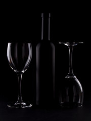 Wine glasses on black backround and wine bottles