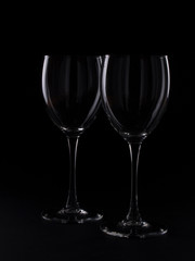 Wine glasses on black backround and wine bottles