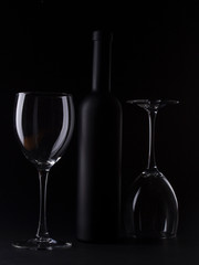 Wine glasses on black backround and wine bottles