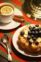 Belgian waffles with blueberry and a cup of tea with lemon
