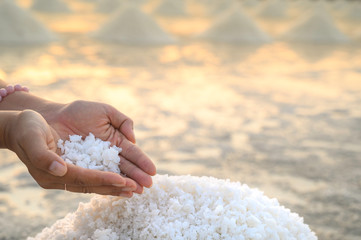 Sea salt, salt scales, salt crystals in a woman's hand