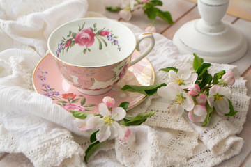 Pretty pink vintage afternoon tea party, tea cup and tender flowers on wooden tray and lace tablecloth - Powered by Adobe