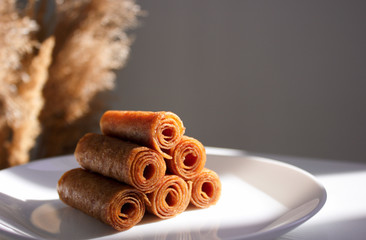 Fruit leather of apples and berries in rolls (Russian pastila). Background for text and articles on healthy eating. Raw food, vegan sweetness, dessert without sugar and flour.