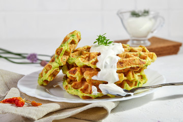 Proper breakfast, healthy Belgian waffles from zucchini with sour cream. On white background.
