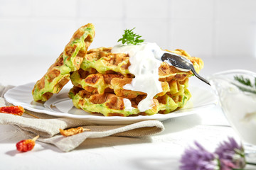 Proper breakfast, healthy Belgian waffles from zucchini with sour cream. On white background.