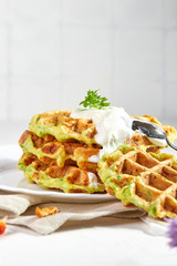 Proper breakfast, healthy Belgian waffles from zucchini with sour cream. On white background.