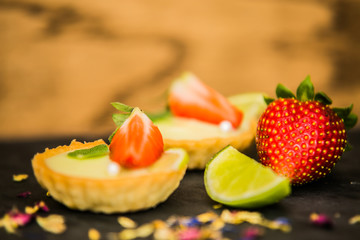 Sweet dessert Tartlets with fresh strawberries and delicious cream. Closeup