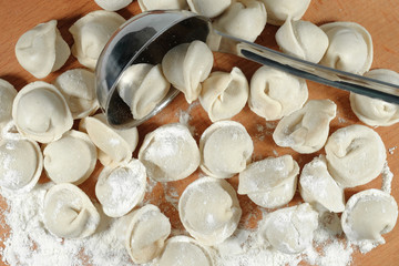 The process of making dumplings. Raw dumplings on a wooden board. Traditional homemade food. Top view