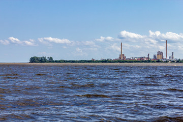Naklejka premium Industrial towers in Guaiba city and Guaiba lake